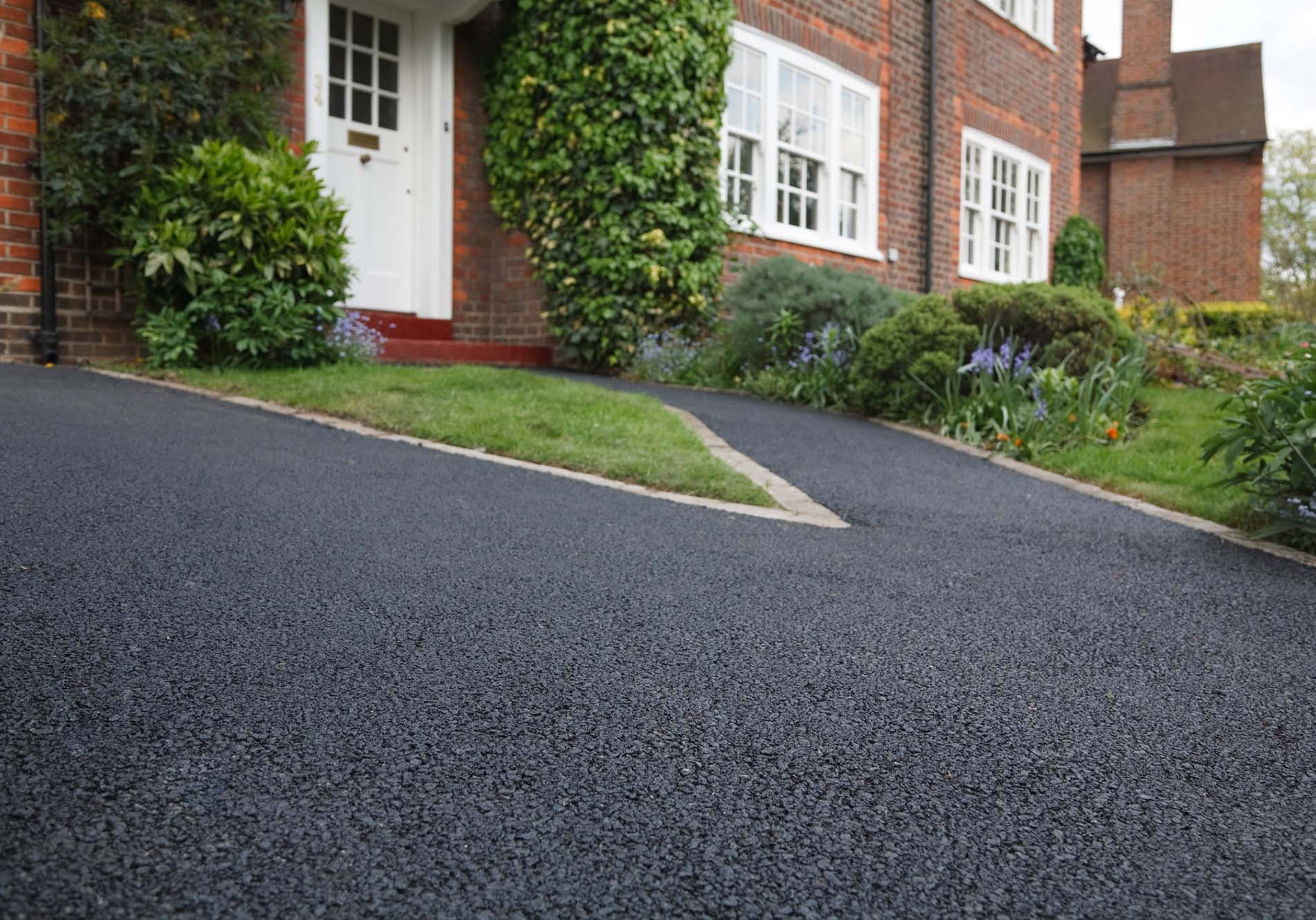 New bitumen driveway outside a beautiful brick house in London.